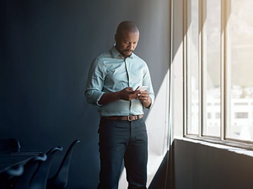 Shot of a mature businessman using a mobile phone in a modern office